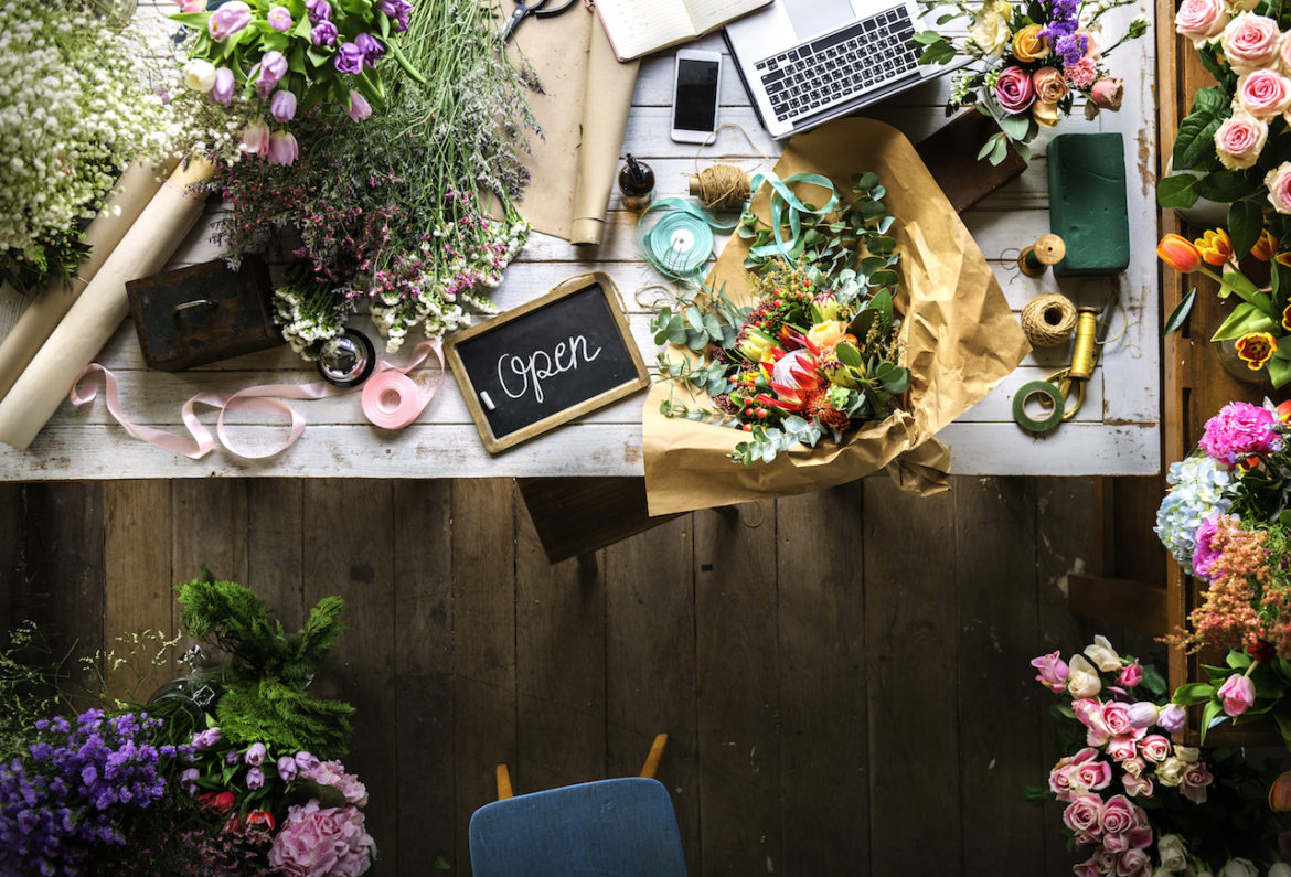 fresh flowers covers white wood table at flora shop with purpose of opening new shop