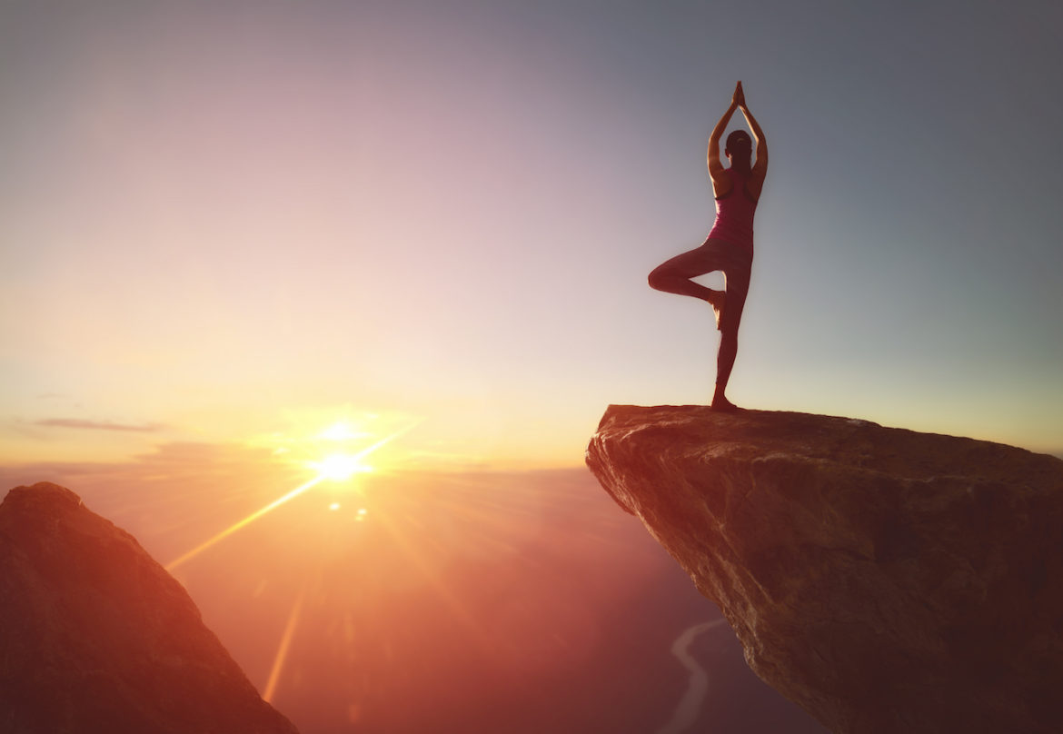 beyond fear a woman practices yoga and meditates on the edge of a cliff only an illusion