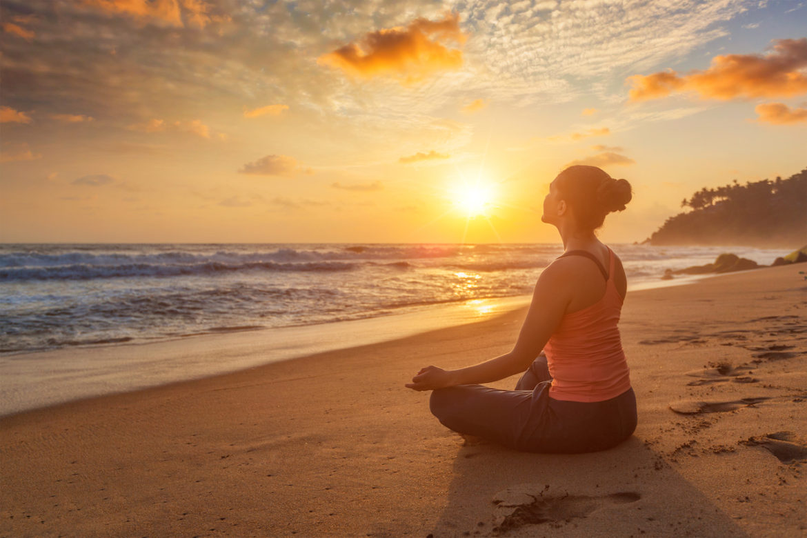 inner harmony woman practicing padmasana lotus pose on the beach at sunset