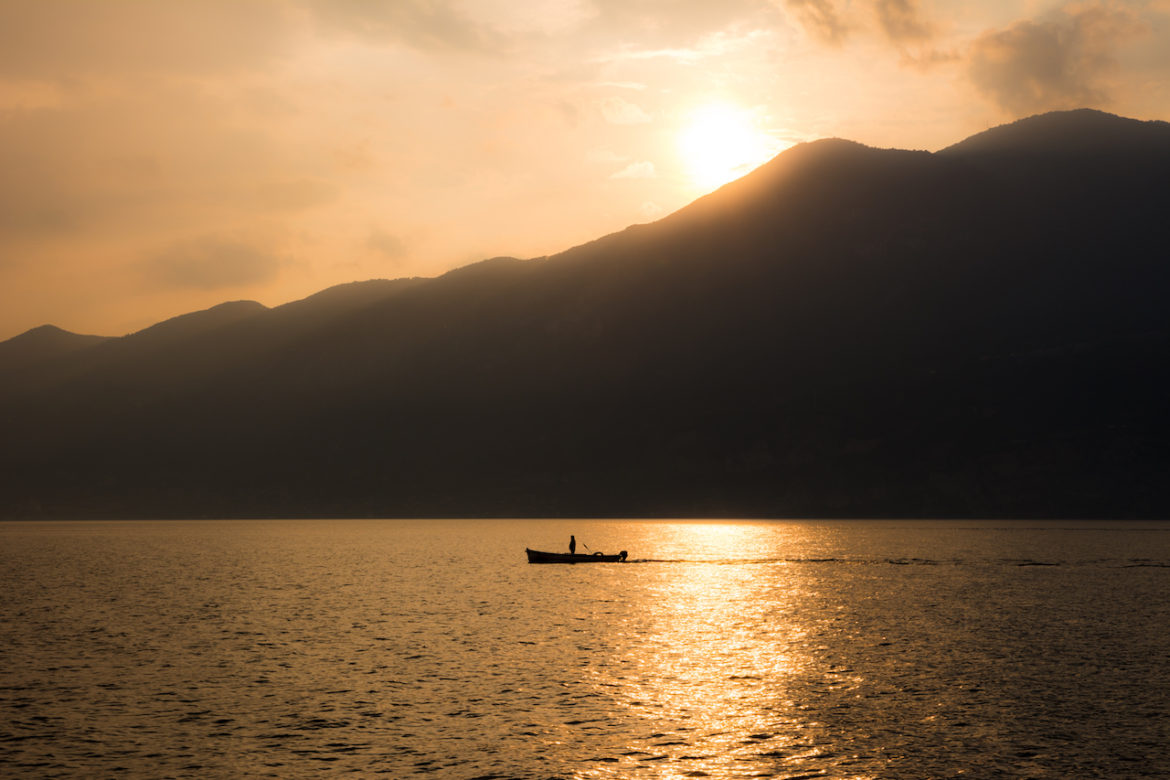 silhouette at sunset on a boat going with the flow managing their expectations at lake Garda Italy