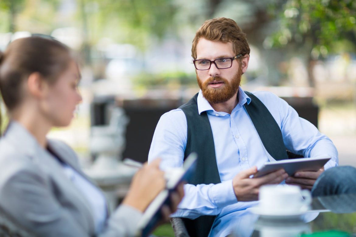 two colleagues take a coffee break outside iPads in hand and he finally honors his intuition by following his heart