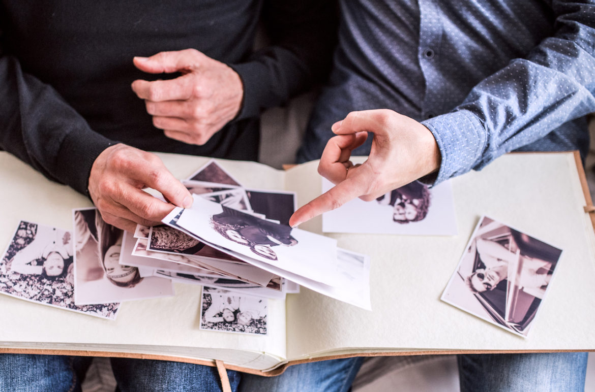 father and son fondly take a walk down memory lane reminiscing over photos of the one that got away