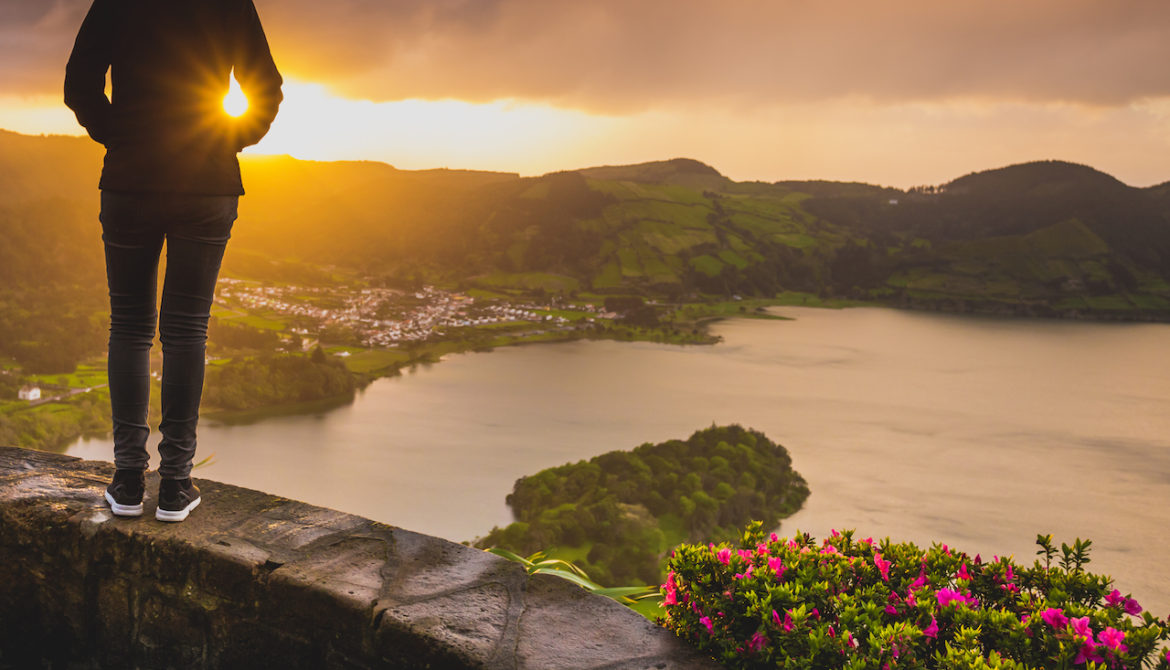 woman admiring the beautiful sunset in Azores, Portugal knowing life goes on