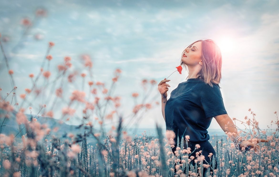 living the dream, woman in a field of wild flowers enjoying the sunshine on a summer day in Italy