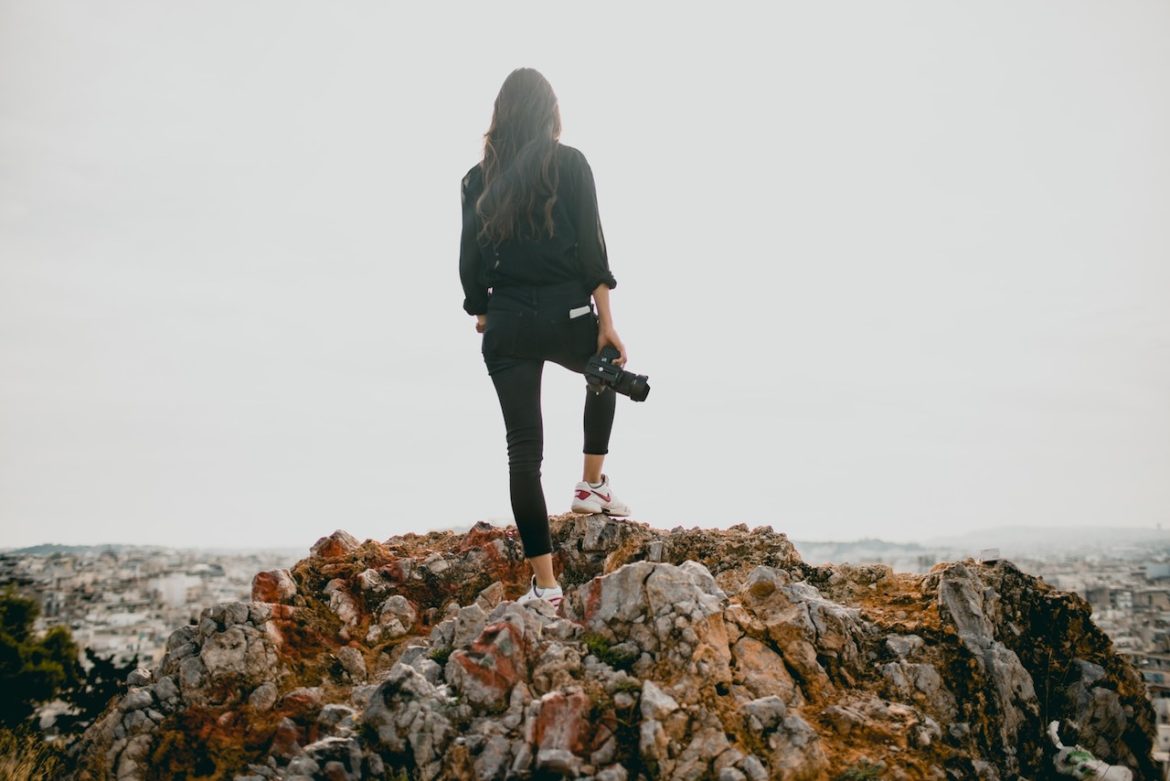 Female photographer standing on a rock on an overcast day in Athens Greece with a plan to succeed