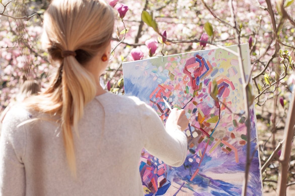 Artist paints blossoming magnolias in Kiev, Ukraine on a sunny summer day knowing it's time to take a chance to create a dream