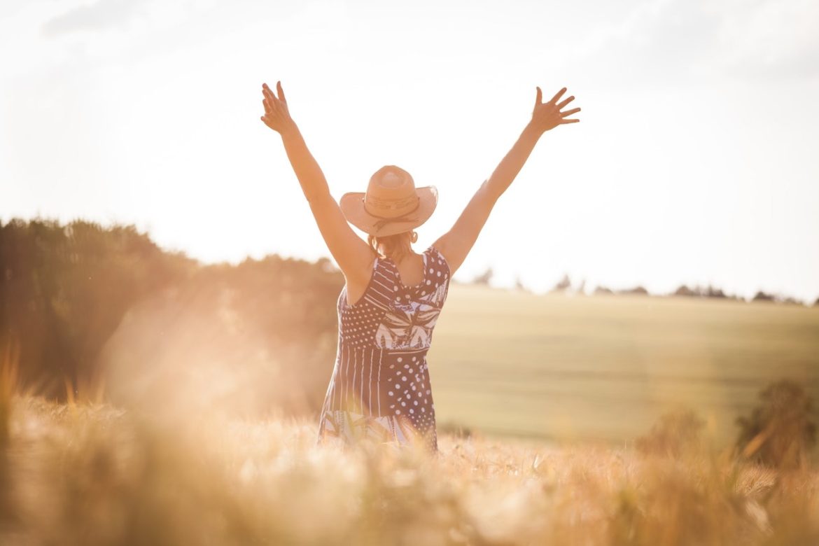 Victory, losing to win and winning. There she stood happily with summer dress and sun hat on, in a prairie field, with outstretched arms reaching out and up, on a summery sunny day.