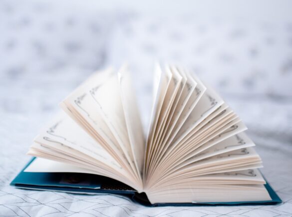 A book lays open on a bed with pages upright like the expansion of an accordion likened to your unfolding story