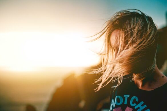 Wind swept hair covering her face, she stands lost after taking bad advice.