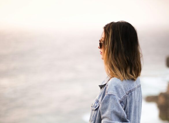 She stands looking out on the ocean, navigating through deception, moving on.