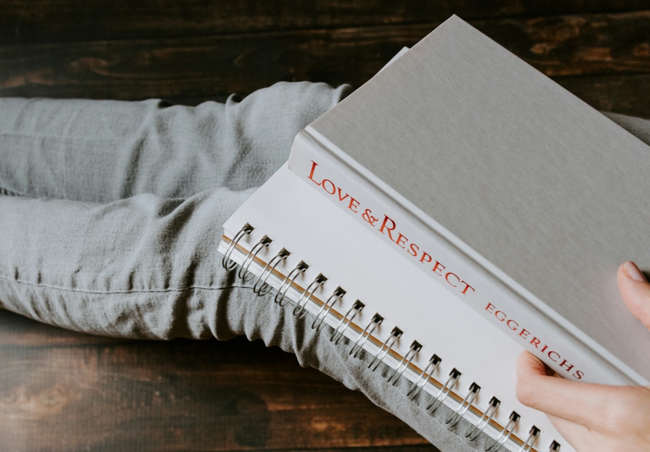 She sits with a journal and a book titled, Love & Respect, a guide to overcoming confusion