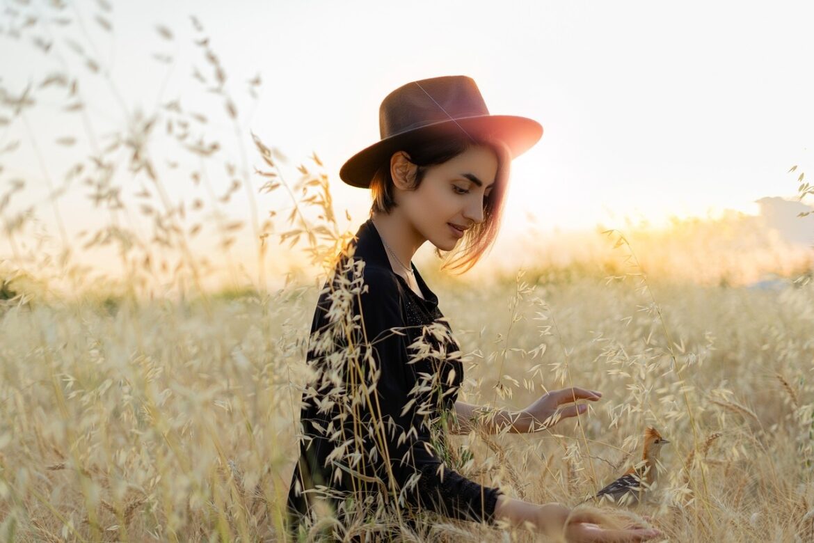 Woman in a field on a autumn day basking with nature finding peace and happiness after creating healthy boundaries.
