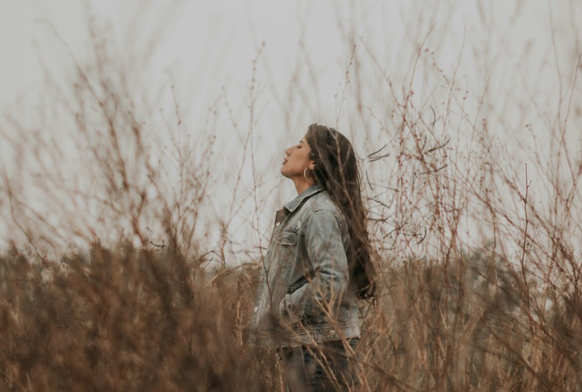 She stands alone in a field of high prairie grass breathing in the fresh air she contemplates whether she should stay or go.